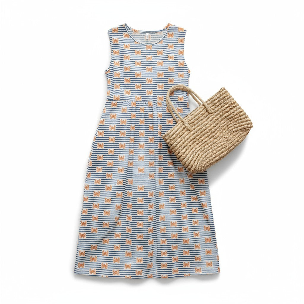 Blue and orange patterned dress with a woven bag on a white background