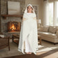 Person wrapped in a white blanket with geometric patterns on a white background