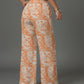 Person wearing orange and white patterned pants in a living room setting.