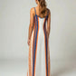 Woman wearing a long Bitcoin maxi dress with blue and orange stripes on a white background