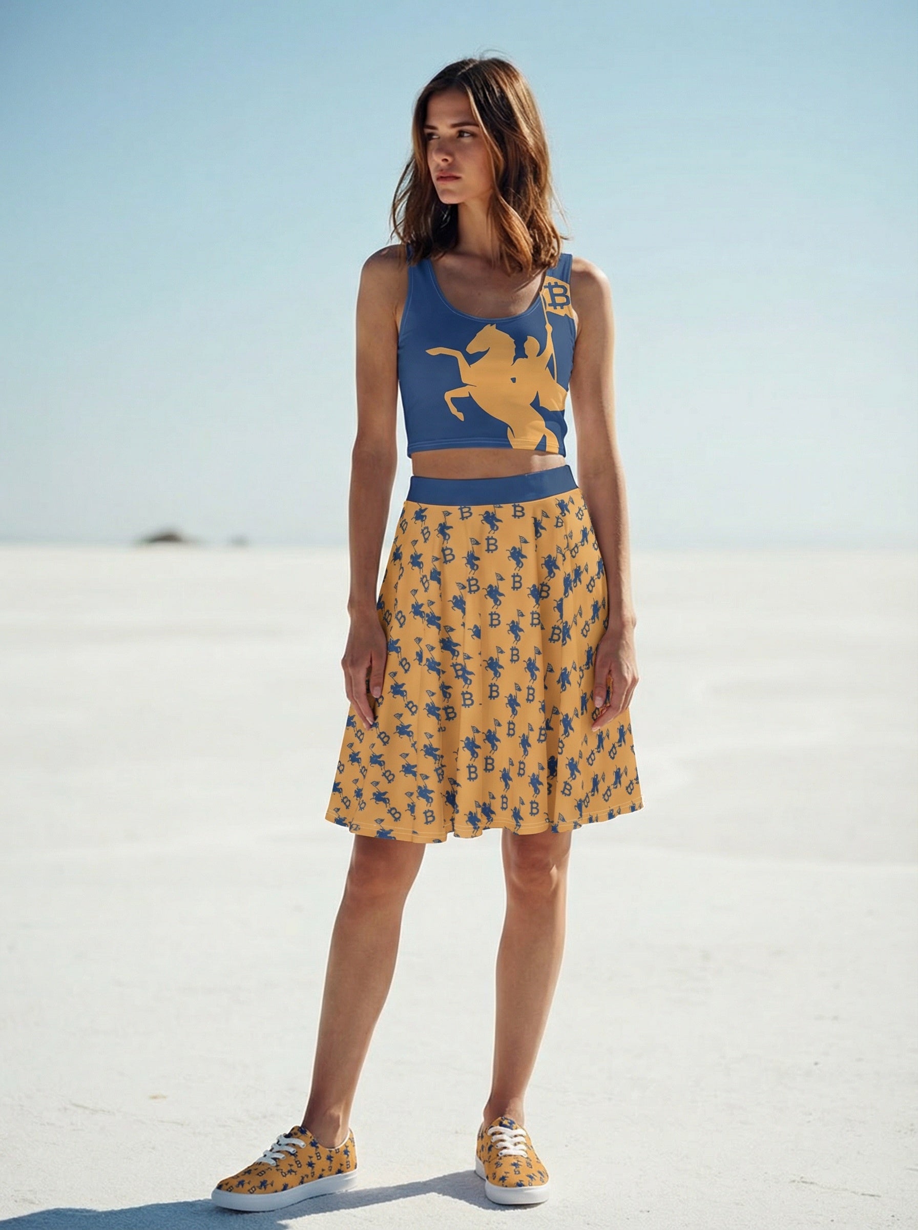Woman wearing a blue top with a horse design and a yellow patterned skirt on a white sandy background.