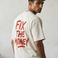 Man wearing a white t-shirt with 'FIX THE MONEY' text in red indoors. SVRN Society