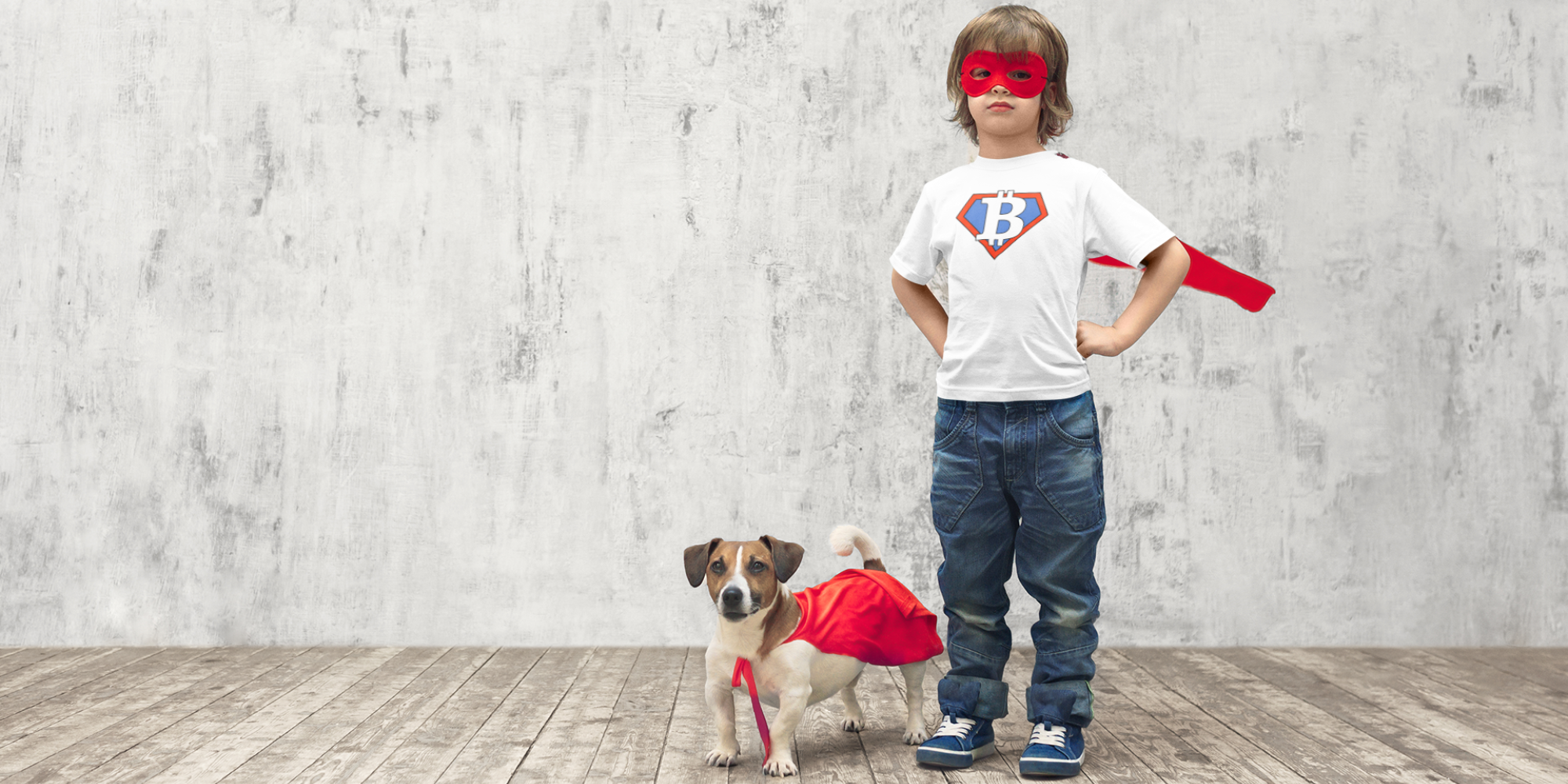Child and dog wearing super B kids bitcoin shirt from SVRN Society, against a concrete wall.