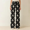 Black Bitcoin themed pants with white pattern worn by a woman on a neutral background SVRN Society