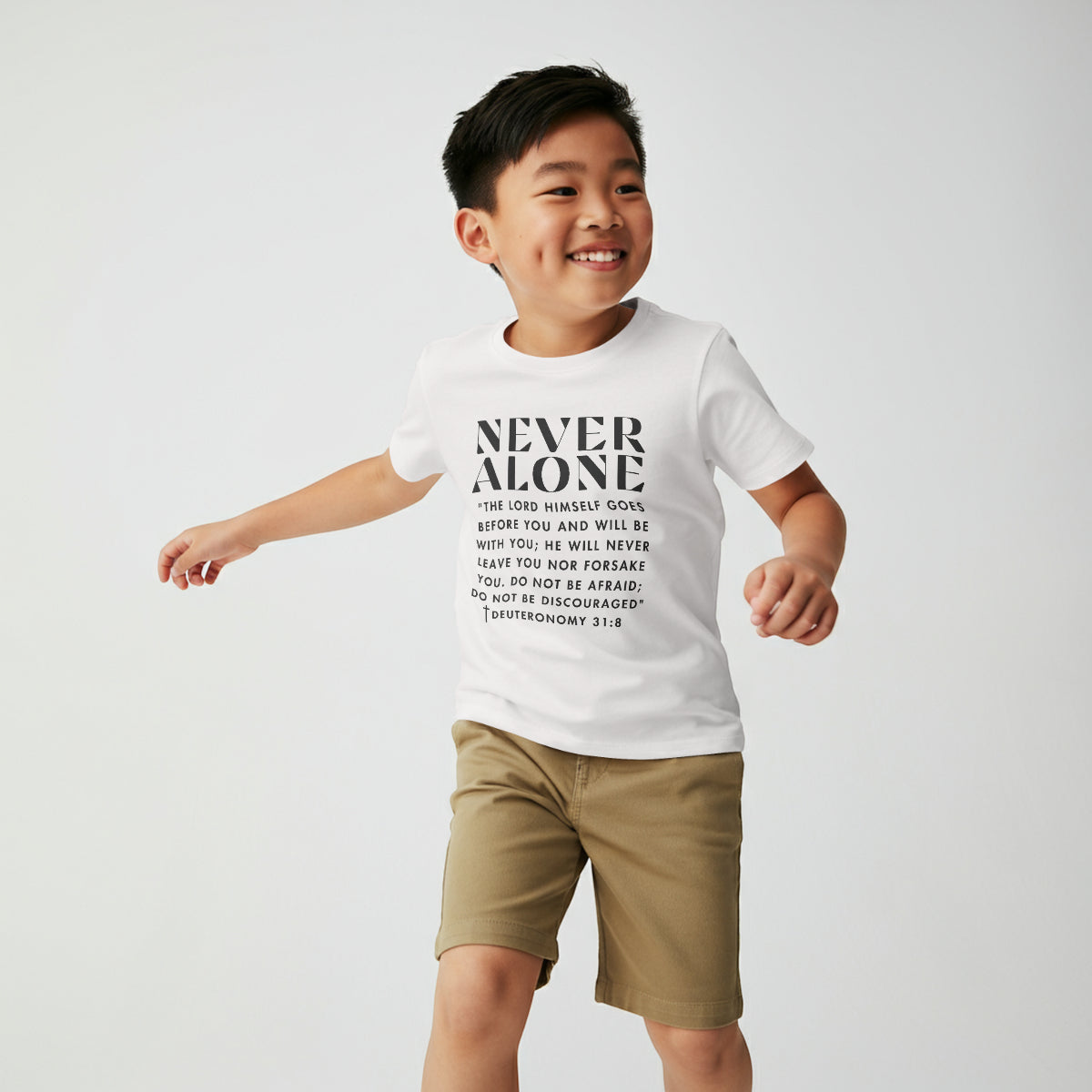 Child wearing a white t-shirt by Praise Society that says Never Alone with Bible verse Deuteronomy 31:8