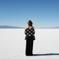 Person standing on a salt flat with a clear blue sky