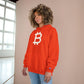 Person wearing an (Orange) Bitcoin hoodie with a Bitcoin logo against a neutral background