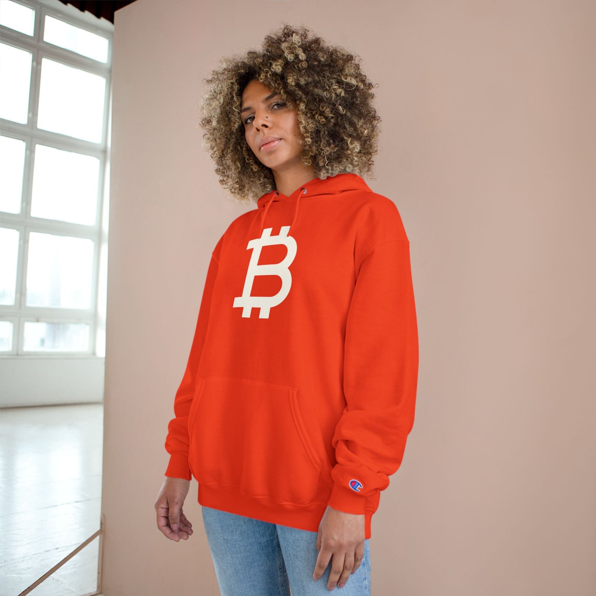 Person wearing an (Orange) Bitcoin hoodie with a Bitcoin logo against a neutral background