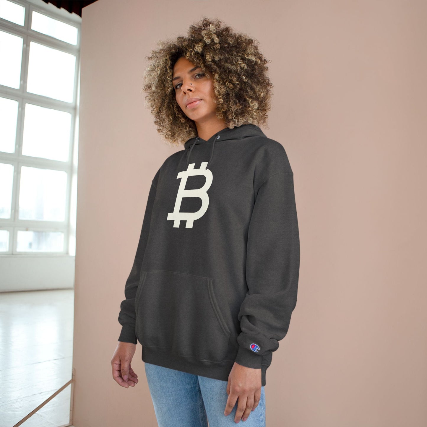 Person wearing a (Charcoal Grey)  hoodie with a Bitcoin logo against a neutral background