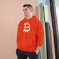 Man wearing a (Orange) Bitcoin hoodie with a Bitcoin logo against a beige wall.