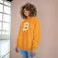 Person wearing a (Gold) hoodie with a Bitcoin logo against a neutral background