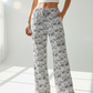 Person wearing white high-waisted pants with black pattern on a white background