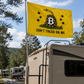 A yellow Gadsden-style flag with a coiled snake, black stars, a large B, and the text 'DON'T TREAD ON ME' mounted on a pole in front of an RV at a campsite.