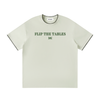 Light green t-shirt with 'FLIP THE TABLES' text on a white background