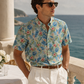 Man wearing a floral bitcoin shirt and sunglasses by the ocean