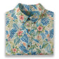 Hawaiian shirt with tropical leaf and flower pattern on a white background