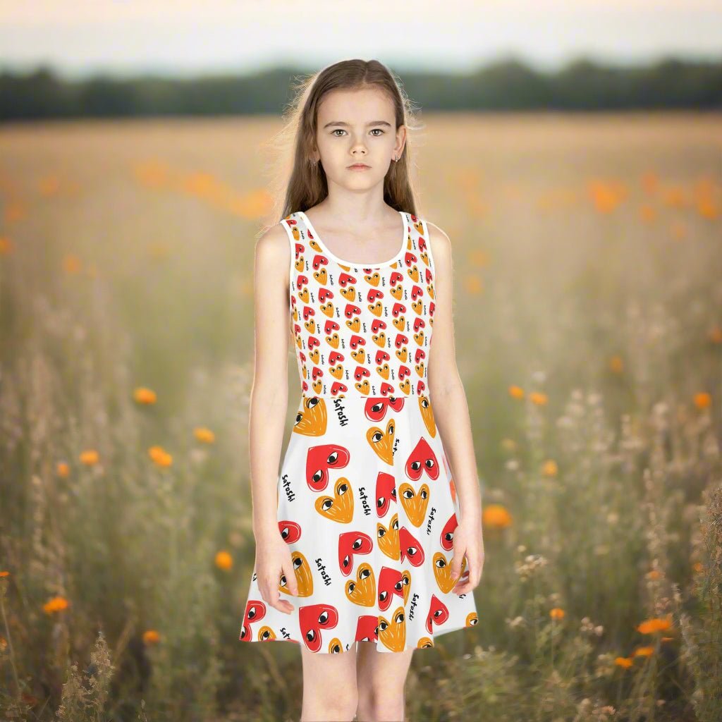 a young girl outside in a field wearing the I HEART SATOSHI Girls Sundress by Lil'B at The Orange Habit