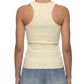 Person wearing a beige tank top and blue jeans on a white background
