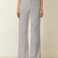 Person wearing blue and white striped pants with a pattern of small crabs on a neutral background