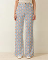 Person wearing blue and white striped pants with a pattern of small crabs on a neutral background