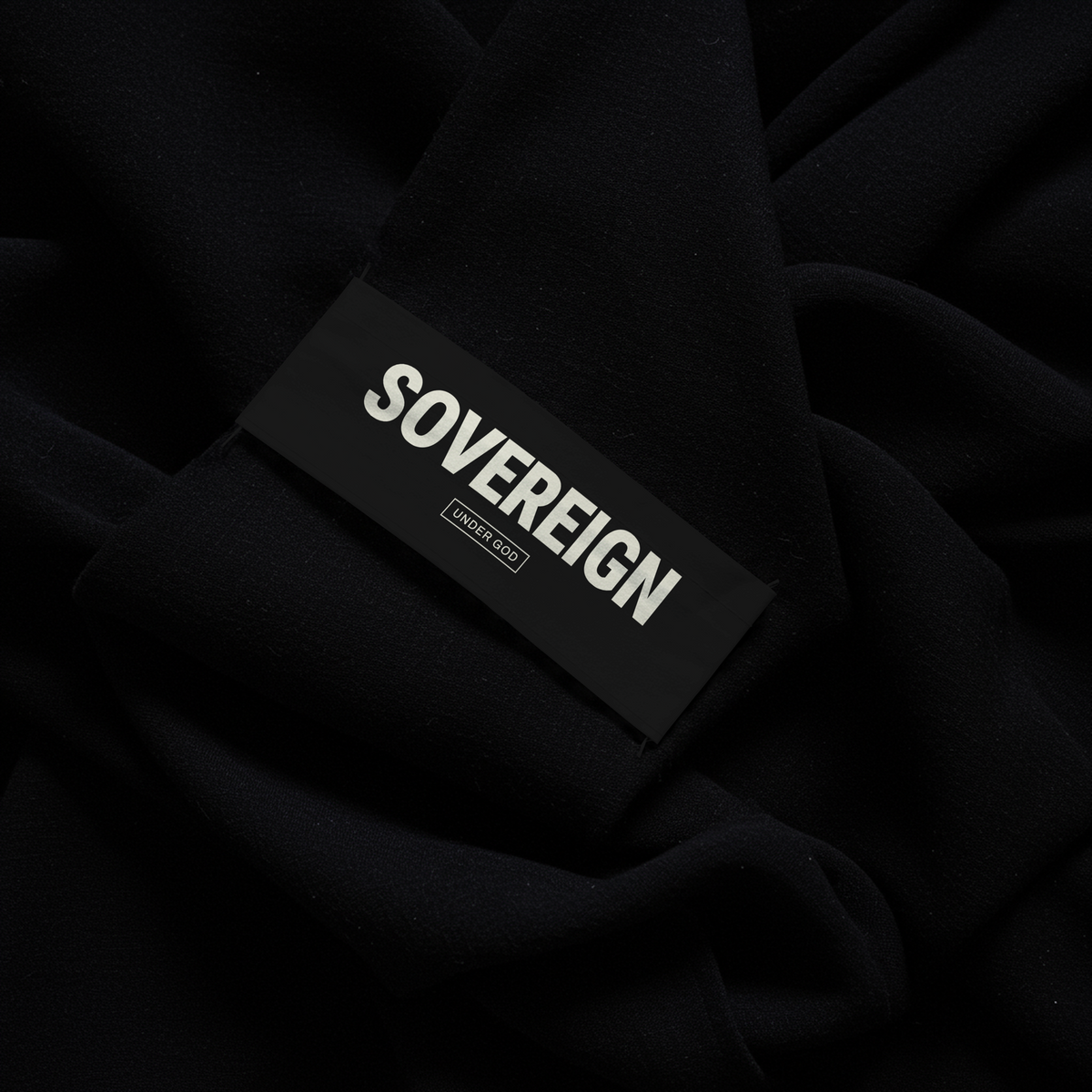 Black label with 'SOVEREIGN' under god text on a dark fabric background