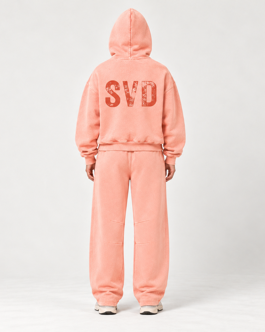 Woman wearing light pink SVD vintage wash hoodie and sweatpants, back view with SVD print