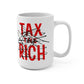 White 15oz mug with red “Tax the Rich” text scribbled out and black side text reading “The system is broken,” designed by The Orange Habit.