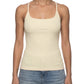Woman wearing a beige tank top and blue jeans on a white background